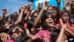 FILE - Rohingya refugee children shout slogans during a protest against repatriation on Nov. 15, 2018. In Myanmar, misinformation, like hate speech and propaganda, fueled violence against Rohingya Muslims. (AP Photo/Dar Yasin)