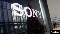 FILE - The logo of Sony Corp and a Christmas tree are reflected on the company's 4K television set at the company's headquarters in Tokyo Nov. 18, 2014. 