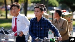 북한 평양 거리에서 주민들이 자전거를 끌고 횡단보도를 건너고 있다. (자료사진)