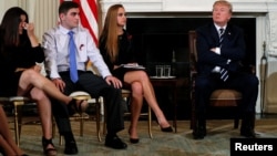 Parent Melissa Blank, from left, and Marjory Stoneman Douglas High School shooting surviving students Jonathan Blank and Julia Cordover attend with other survivors and the families of victims a listening session held by U.S. President Donald Trump to discuss school safety and shootings, at the White House in Washington, Feb. 21, 2018. 