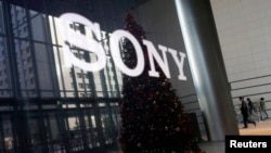 FILE - The logo of Sony Corp and a Christmas tree are reflected on the company's 4K television set at the company's headquarters in Tokyo, Nov. 18, 2014. 