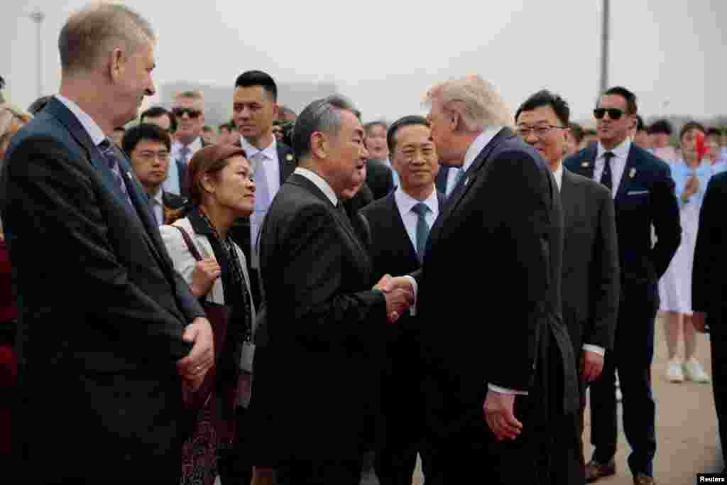美国总统特朗普在准备登上“空军一号”专机返回美国之前，与前来送行的中国外长王毅握手。(2026年5月16日)