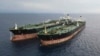 In this undated photo released July 11, 2023, by the Indonesian Maritime Security Agency, Iranian-flagged tanker MT Arman 114, right, and Cameroon-flagged tanker, MT S Tinos, are seen after they are caught conducting illegal oil transfers.