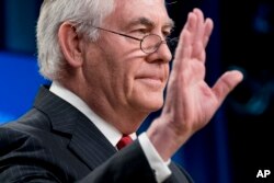 FILE - Rex Tillerson waves goodbye after speaking at a news conference at the State Department in Washington, following his dismissal as secretary of state, March 13, 2018.