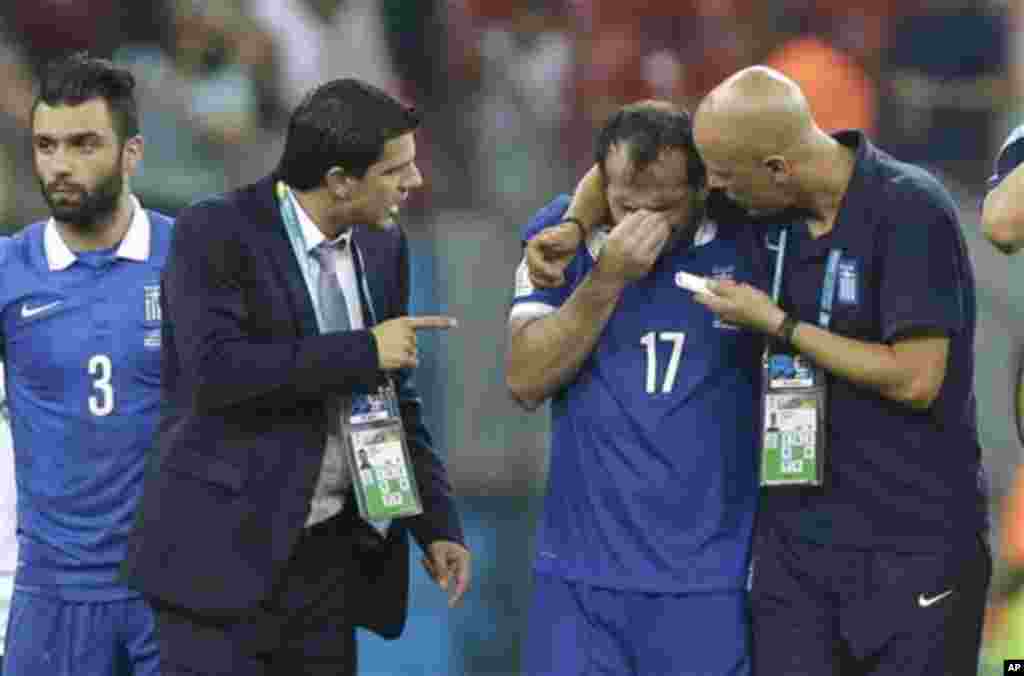 Greece's Fanis Gekas, center, is consoled by his teammates after a penalty shootout at the end of the World Cup round of 16 soccer match between Costa Rica and Greece at the Arena Pernambuco in Recife, Brazil, Sunday, June 29, 2014. Costa Rica won 5-3 on