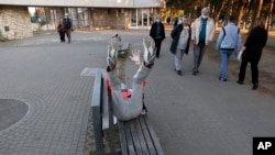 Un homme portant un masque contre la propagation du nouveau coronavirus, fait des exercides dans un parc lors d'une suspension du couvre-feu à Belgrade, en Serbie, vendredi 24 avril 2020. (AP Photo / Darko Vojinovic) penzioneri srbija