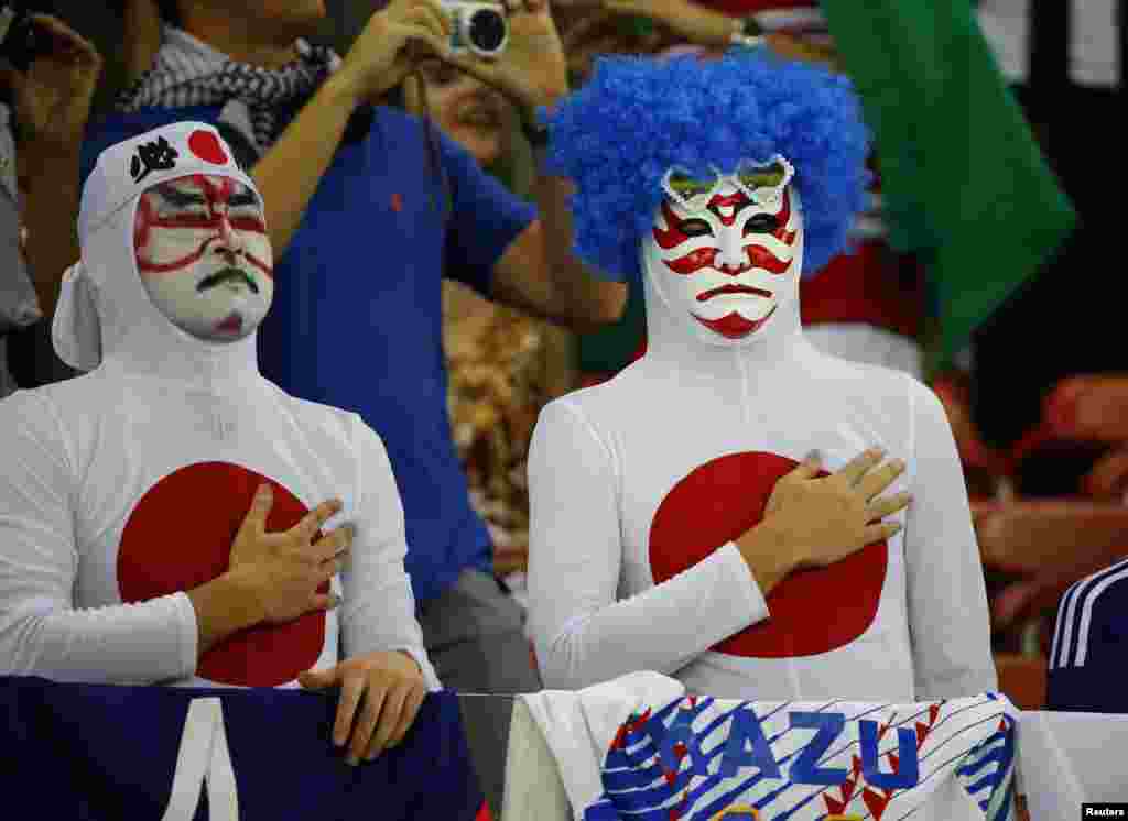 Para penggemar Jepang menyanyikan lagu kebangsaan sebelum pertandingan antara Jepang dan Pantai Gading dimulai di Recife, Brazil (14/6).