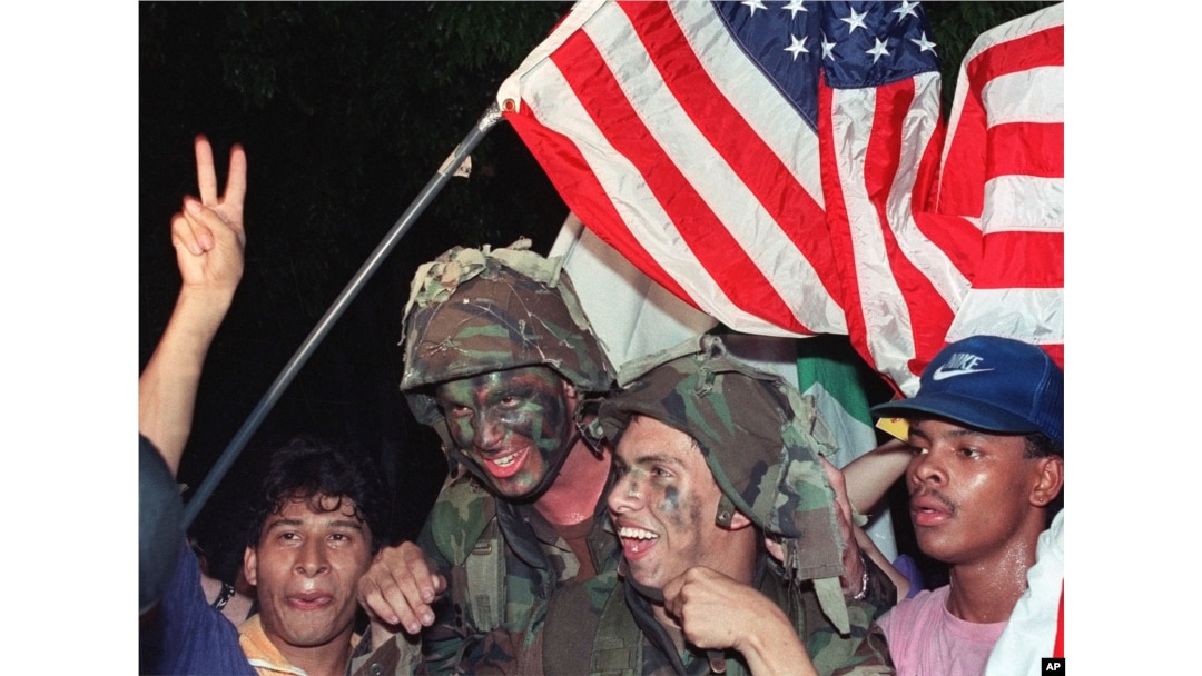 U.S. soldiers carry an American flag through the streets of Panama City as they celebrate with Panamanian citizens in Jan. 1990 following the surrender of Panamanian leader Manuel Noriega.