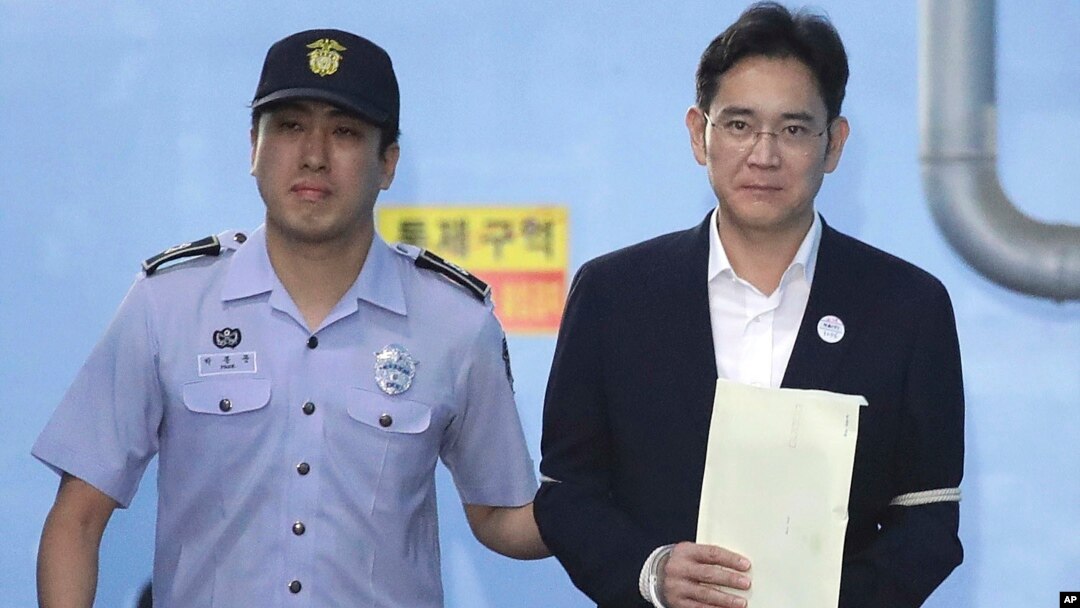 Miliuner pewaris Samsung, Lee Jae-yong (kanan), meninggalkan gedung pengadilan di Seoul dengan diborgol dan dikawal polisi akhir Agustus lalu (foto: dok). 