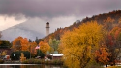 Dedaunan musim gugur menambah warna pada hari hujan di sepanjang Sungai Androscoggin di Berlin, New Hampshire.