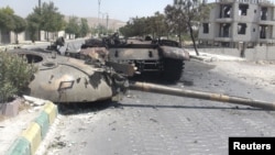 A destroyed Syrian army tank is seen in the Damascus suburb of al-Tel July 28, 2012. 