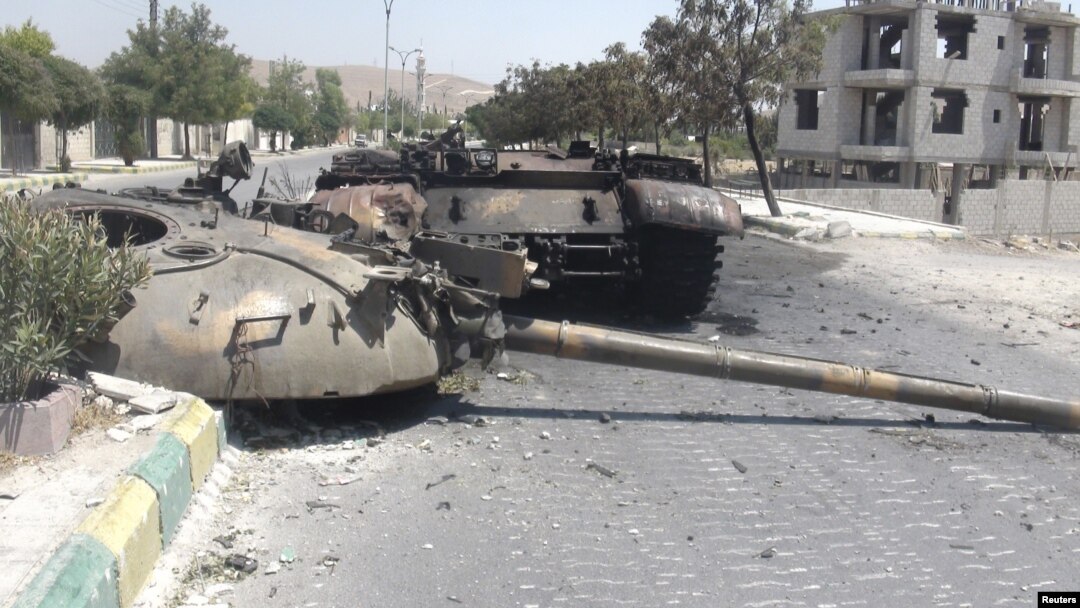 A destroyed Syrian army tank is seen in the Damascus suburb of al-Tel July 28, 2012. 
