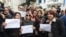 Tunisian journalists wearing red armbands protest with signs outside the headquarters of the National Union of Tunisian Journalists against police threats and intimidation in the capital Tunis on Feb. 2, 2018, holding signs reading in Arabic and French: "The Tunisian press is angry." 