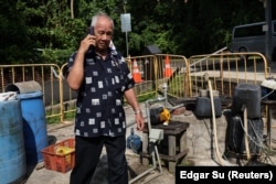 Resident Chu Yok Choon, 79, passes a village well on Singapore’s Pulau Ubin island, November 1, 2024. (REUTERS/Edgar Su)