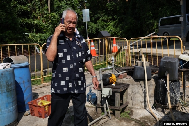 Resident Chu Yok Choon, 79, passes a village well on Singapore’s Pulau Ubin island, November 1, 2024. (REUTERS/Edgar Su)