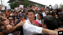 Thailand's Future Forward Party leader Thanathorn Juangroongruangkit, center, is mobbed by his supporters upon arrival at a police station Bangkok, Thailand, April 6, 2019. 