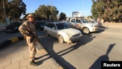A security officer patrols the city ahead of Libya's two-year anniversary marking the ouster of Moammar Gadhafi, Benghazi, Feb. 12, 2013.