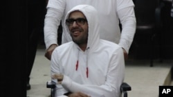 FILE - Mohamed Soltan, in a wheelchair, makes a court appearance in Cairo, Egypt, March 9, 2015. 