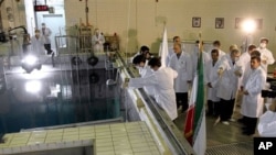 Iranian President Mahmoud Ahmadinejad, right, is escorted by technicians during a tour of Tehran's research reactor center in northern Tehran, February 15, 2012.