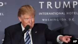 FILE - U.S. President-elect Donald Trump, still a presidential candidate at the time, speaks during the grand opening of Trump International Hotel in Washington, D.C., Oct. 26, 2016. Experts say that anything short of Trump selling off his global holdings before he assumes power would inevitably present complications during his time in office.