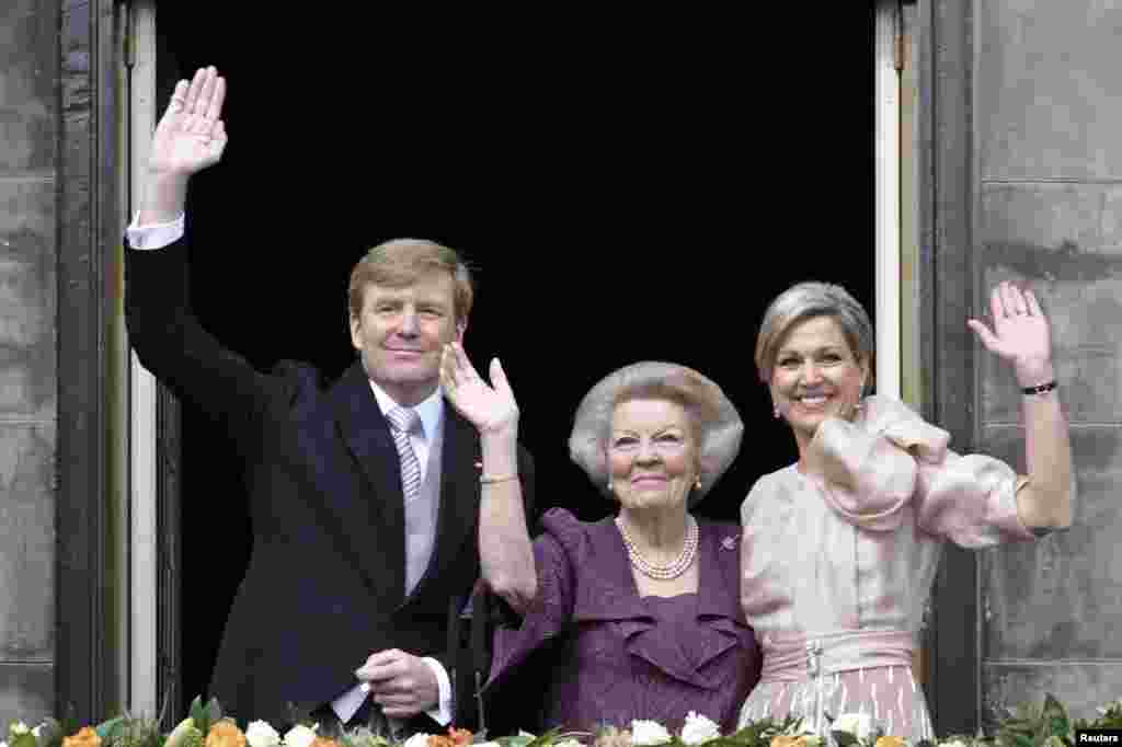 Putri Beatrix dari Belanda (tengah), putranya, Raja Belanda Willem-Alexander yang berusia 46 tahun dan istrinya Ratu Maxima melambaikan tangan kepada kerumunan warga dari balkon Istana Kerajaan di Amsterdam. 