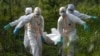 Des agents d'inhumation vêtus de tenues de protection portent les restes d'une victime du virus Ebola, à Beni, en RDC, le dimanche 14 juillet 2019.