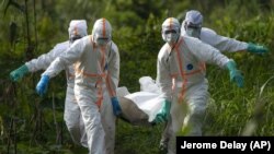 In this Sunday, July 14, 2019 photo, burial workers dressed in protective gear carry the remains of Mussa Kathembo, an Islamic scholar who had prayed over those who were sick, in Beni, Congo. Photo/Jerome Delay)