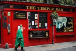 A man dressed as St. Patrick walks past a closed pub in Dublin, Ireland, March 16, 2020. (AP File Photo)