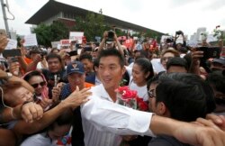 Thailand's Future Forward Party leader Thanathorn Juangroongruangkit, center, is mobbed by his supporters upon arrival at a police station Bangkok, Thailand, April 6, 2019.