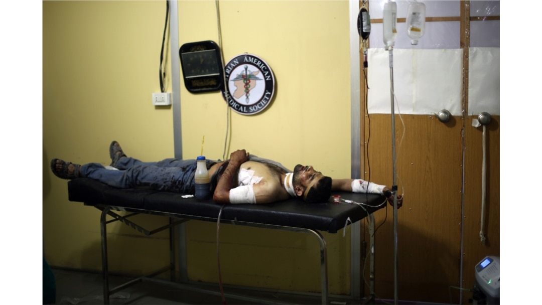 FILE - A wounded man is treated at a medical center of the Syrian American Medical Society (SAMS) following reported airstrikes, in the town of Kfar Batna, Syria, June 11, 2016.