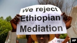 A Sudanese supporter of the military council, holds a placard during a sit-in against Ethiopian mediation, outside the Ethiopian embassy, in Khartoum, Sudan, June 25, 2019. 