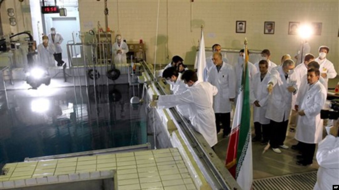 Iranian President Mahmoud Ahmadinejad, right, is escorted by technicians during a tour of Tehran's research reactor center in northern Tehran, February 15, 2012.