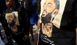 Guests wear T-shirts in tribute to Nipsey Hussle, whose given name was Ermias Asghedom, at the late rapper's Celebration of Life memorial service, April 11, 2019, at the Staples Center in Los Angeles.