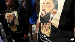 Guests wear T-shirts in tribute to Nipsey Hussle, whose given name was Ermias Asghedom, at the late rapper's Celebration of Life memorial service, April 11, 2019, at the Staples Center in Los Angeles.