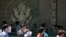 FILE - In this July 26, 2018, photo, visa applicants wait to enter the U.S. Embassy in Beijing, China. The U.S. Homeland Security Department says more than 700,000 foreigners who were supposed to leave the country during a recent 12-month period overstayed their visas.