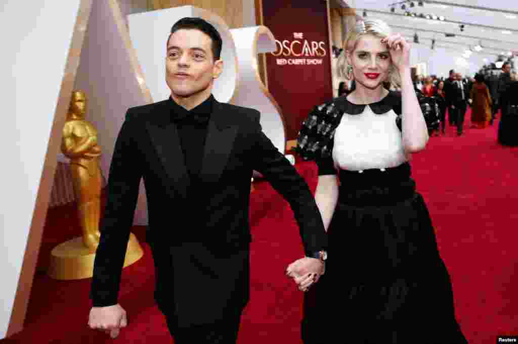 Rami Malek and Lucy Boynton walk on the red carpet during the Oscars arrivals at the 92nd Academy Awards in Hollywood, Los Angeles, Feb. 9, 2020. 