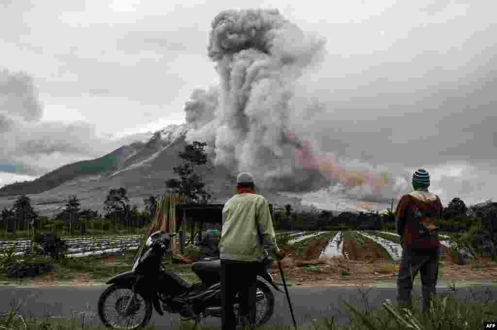Indonesian villagers watch an eruption of Mount Sinabung volcano in Karo, North Sumatra.