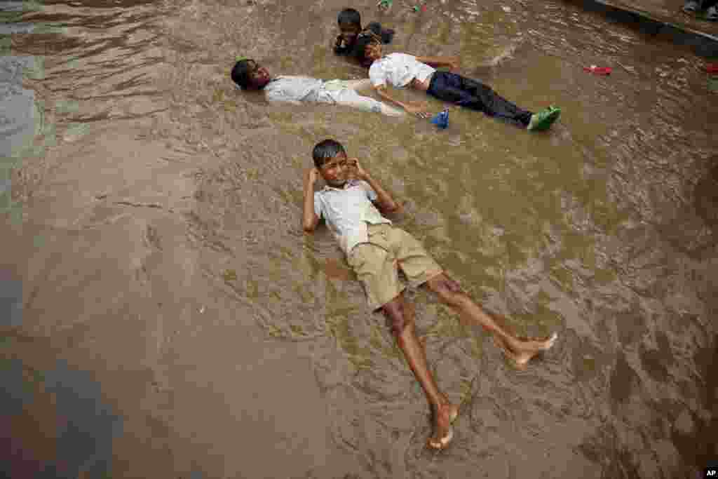Trẻ em Ấn Ðộ chơi đùa dưới mưa ở Ahmadabad. Những trận mưa mùa thường diễn ra ở Ấn Ðộ từ tháng 6 tới tháng 9.