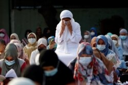 Reaksi umat Islam saat salat di Masjid Agung Al Azhar saat Idul Fitri menandai akhir bulan suci Ramadhan, di tengah pandemi COVID-19 di Jakarta, 13 Mei 2021. (Foto: REUTERS/Willy Kurniawan)