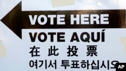 FILE - A sign is posted outside an election site in the Borough Park section of the Brooklyn borough of New York, Nov. 4, 2014. The sign reads "Vote Here" in English, Spanish, Chinese, and Korean. (AP Photo/Mark Lennihan) 