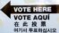 FILE - A sign is posted outside an election site in the Borough Park section of the Brooklyn borough of New York, Nov. 4, 2014. The sign reads "Vote Here" in English, Spanish, Chinese, and Korean. (AP Photo/Mark Lennihan) 