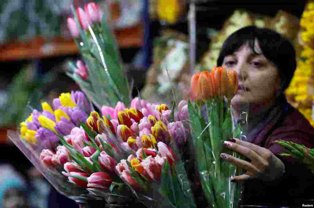 Seorang pegawai toko bunga menata rangkaian bunga di sebuah pasar bunga menjelang peringatan Hari Perempuan Internasional di Moscow, Rusia, 6 Maret 2019. (Foto: Reuters)