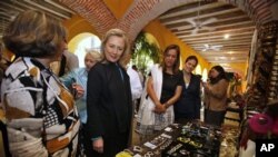 U.S. Secretary of State Hillary Rodham Clinton, second from left, admires items made by women entrepreneurs as she is greeted by some of the women before the media launch of the Women's Entrepreneurship in the Americas program in Cartagena, Colombia.