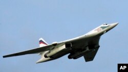 FILE - A supersonic Tu-160 strategic bomber flies above an airfield near the northern city of Murmansk, Aug. 16, 2005. Two Russian strategic bombers landed in Venezuela on Wednesday as part of military maneuvers.
