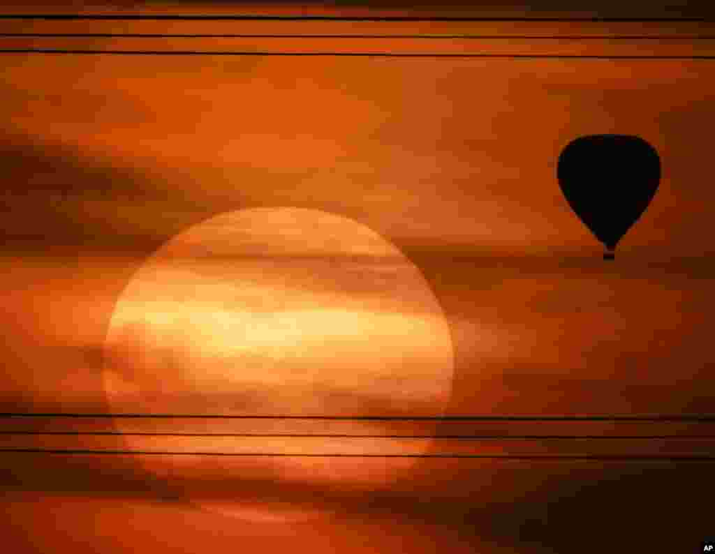 A hot air balloon is silhouetted against the evening sky as the sun sets north of Phoenix, Arizona, USA, March 2, 2016.