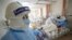 Medical workers in protective suits attend to a patient inside an isolated ward of Wuhan Red Cross Hospital in Wuhan, Hubei province, China, Feb. 16, 2020. 