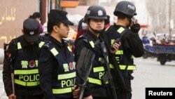 FILE - Armed police keep watch in a street in Kashgar, Xinjiang Uighur Autonomous Region, China, March 24, 2017. 