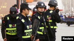 FILE - Armed police keep watch in a street in Kashgar, Xinjiang Uighur Autonomous Region, China, March 24, 2017. 