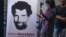 A journalist stands in front of a poster featuring jailed businessman and philanthropist Osman Kavala during a press conference held by his lawyers, Oct. 31, 2018.