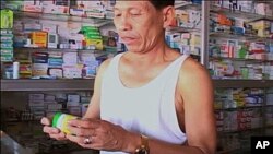 Cambodian man purchases malaria medicine at local pharmacy